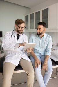 Patient education and guidance. Attentive doctor shares expertise with male visitor on consultation about disease diagnosis